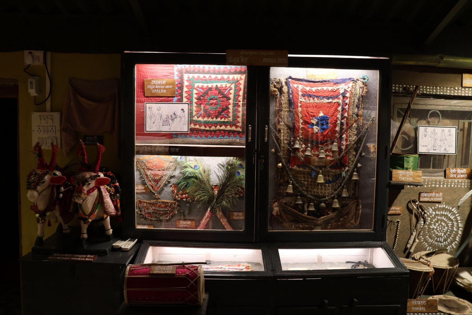 A display of Pangul Bail art, featuring decorative cloths, ornaments, and models of bulls used by theThakarcommunityduring performances. (Source: CKA Archives)