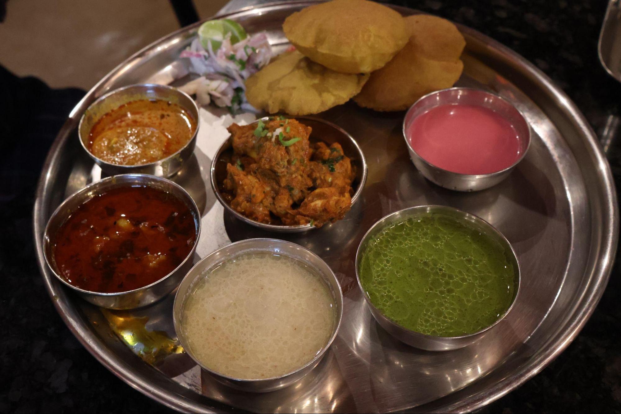 A thaali featuring solkadhi, gavran chicken cooked with malvani masala, crisp golden vadas, and a variety of local accompaniments. (Source: CKA Archives)
