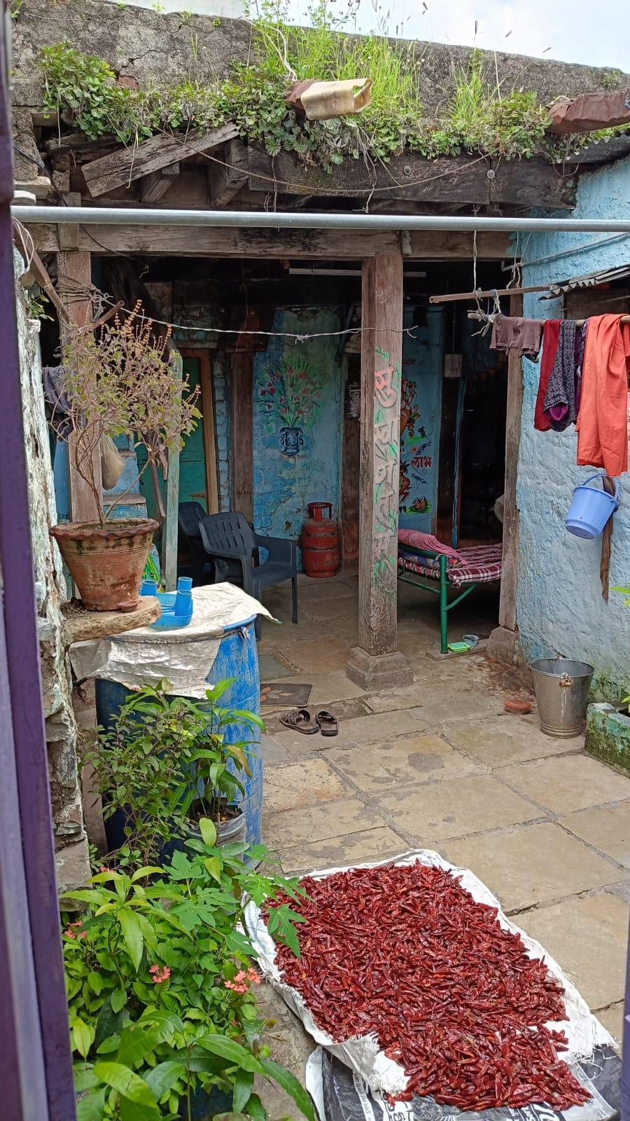 Courtyard of the house where various functions of the house are carried out. Notice the traditional way of drying red chillies. (Source: CKA Archives)