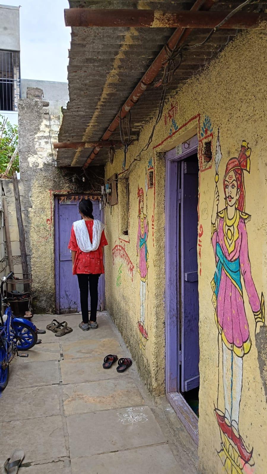 Interestingly, the door is painted purple, providing a beautiful contrast to the yellow wall. The wall features murals of guards. (Source: CKA Archives)